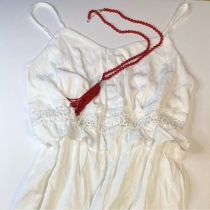 White spaghetti strap short dress. Eyelet detailing at waist and bottom.